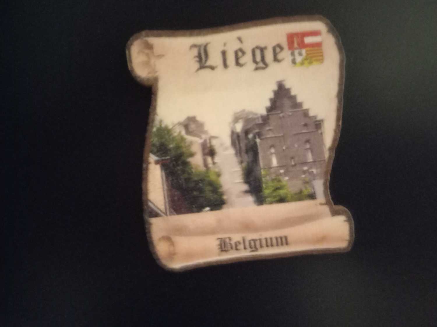 Magnes z Liege w kształcie pergaminu z malunkiem kamienic.